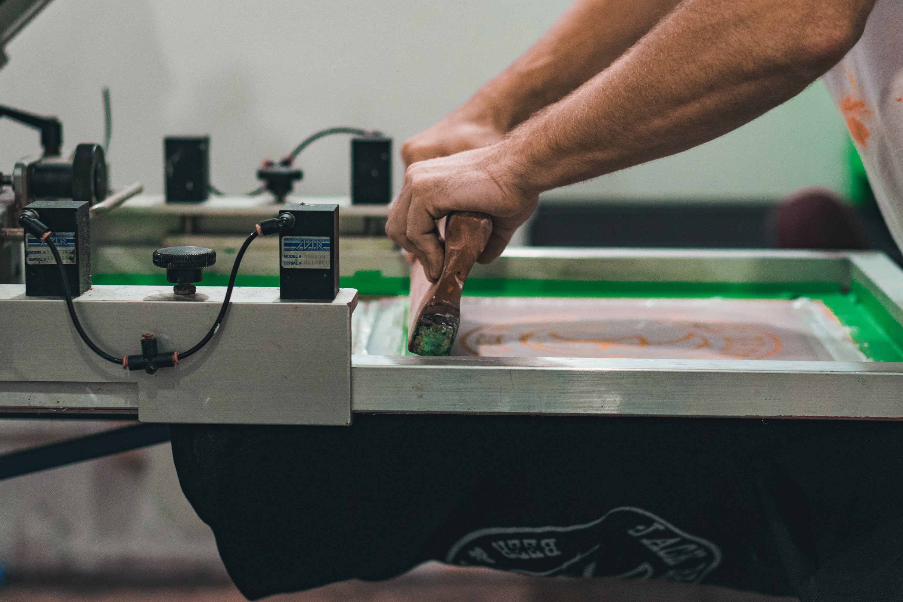 Screen printing press preparing custom apparel.